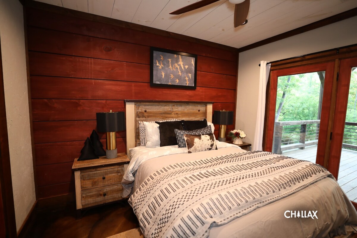 Queen-sized bedroom (lower level) with television, balcony/hot-tub access, and on-suite bathroom.