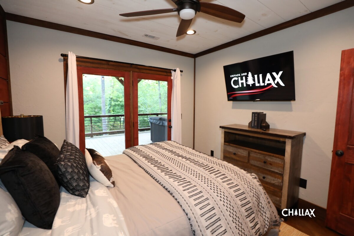Queen-sized bedroom (lower level) with television, balcony/hot-tub access, and on-suite bathroom.
